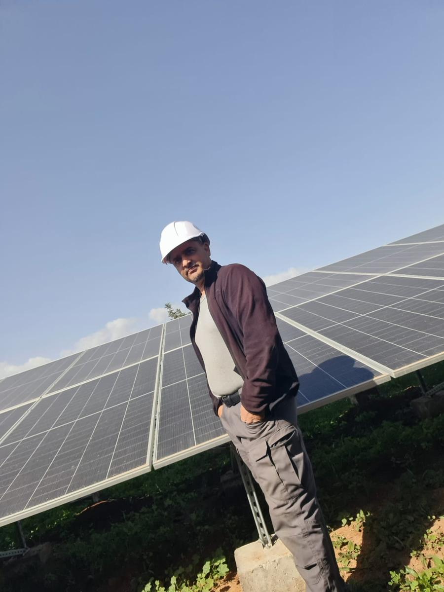 Technicien Sunenergy devant un champ de panneaux solaires
